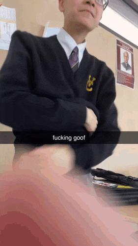 a man in a suit and tie has the word goof on his shirt