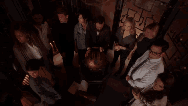 a group of people are gathered around a machine that says ' i 'm a genius ' on it