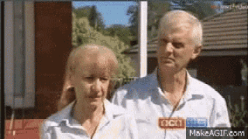 a man and a woman are standing next to each other and looking at the camera .