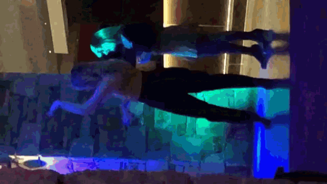 a man and a woman are standing on a set of stairs with blue lights behind them