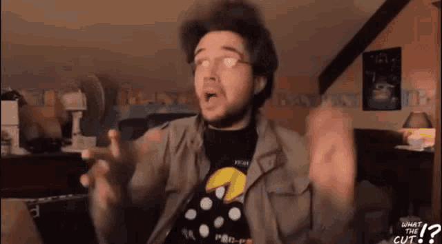 a man is wearing a pac man shirt and talking