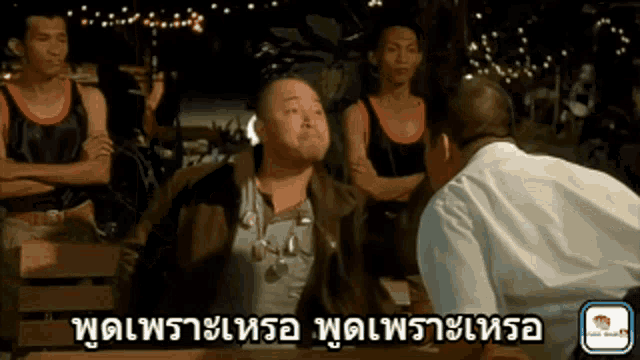 a man in a white shirt is talking to another man in a brown jacket in a foreign language