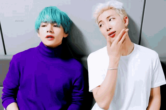 a man with blue hair is standing next to another man