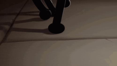a shadow of a person 's legs is cast on a wall