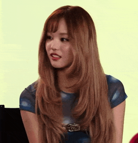 a woman with long hair is wearing a blue top