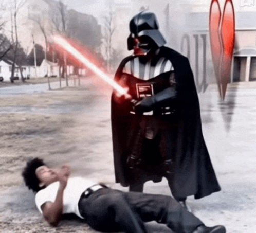 darth vader is standing next to a man on the ground