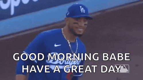 a baseball player wearing a la hat is giving a thumbs up .