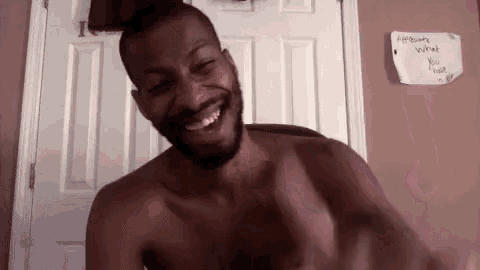 a shirtless man is smiling in front of a door with a note on it that says appreciate what you have
