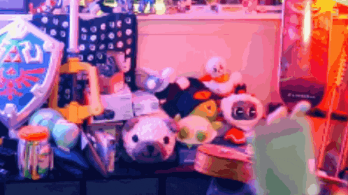 a bunch of stuffed animals are on a table with a shield that says ' zelda ' on it