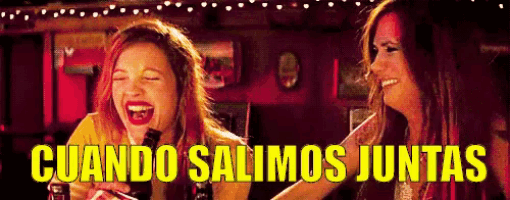 two women are laughing in a bar and the words cuando salimos juntas are visible