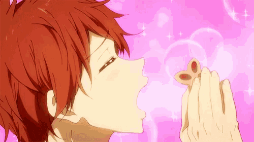 a boy with red hair is holding a butterfly in his hand and kissing it .