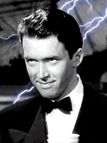 a black and white photo of a man in a tuxedo with lightning in the background