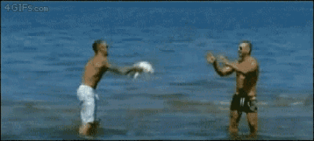 two men are playing with a dog in the water and the website 4gifs.com is visible