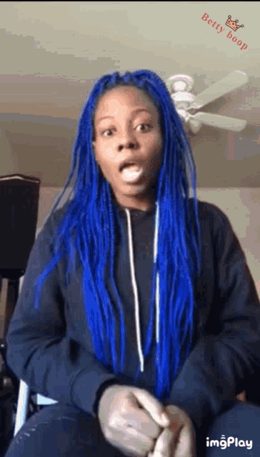 a woman with blue braids has a betty hoop logo on the bottom