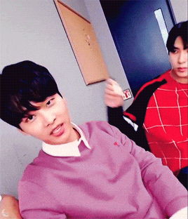 a man in a purple sweater is sitting next to a man in a red shirt
