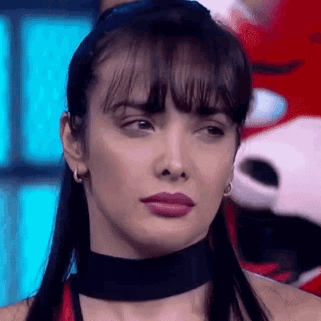 a close up of a woman 's face with a choker around her neck .