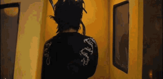 a man with dreadlocks is standing in front of a yellow door .