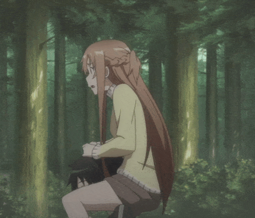 a girl is hanging upside down from a tree in a forest