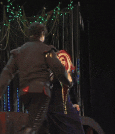 a man in a black jacket stands next to a woman