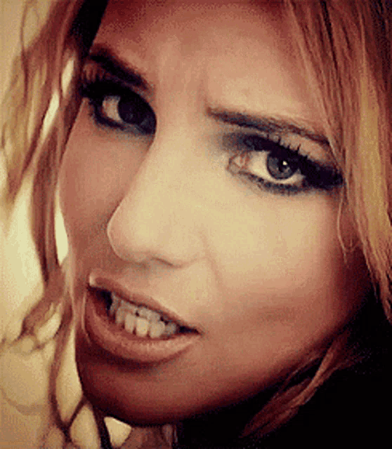 a close up of a woman 's face showing her teeth