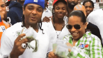 a man in a blue hat holds a stack of money