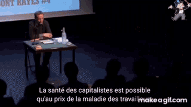 a man is giving a speech in front of a microphone in french .