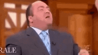 a man in a suit and tie is giving a speech on a tv show .