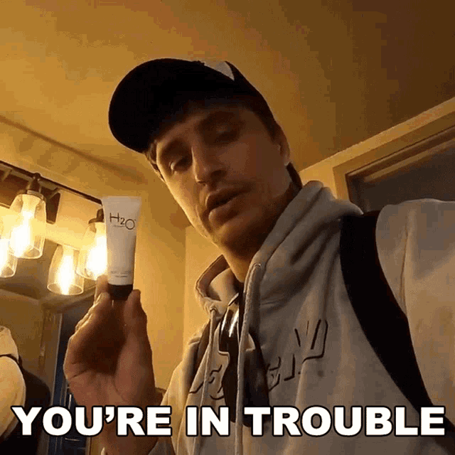 a man is holding a tube of h2o cream and says you 're in trouble