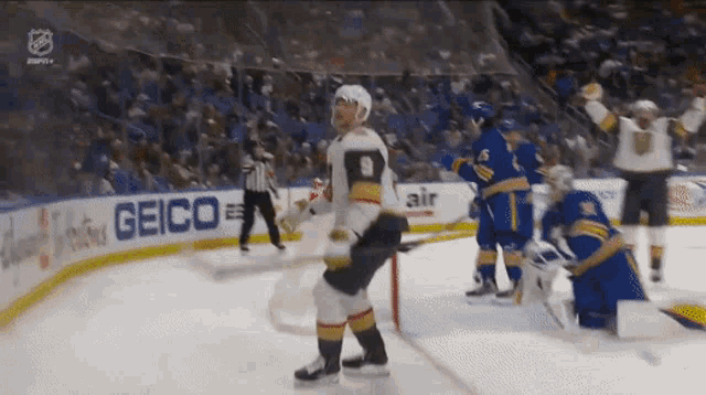 a hockey player with the number 9 on his jersey stands on the ice