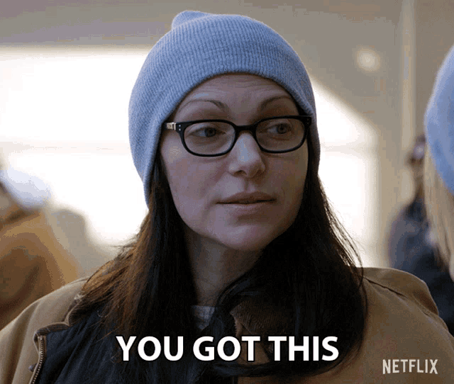 a woman wearing glasses and a blue beanie says you got this