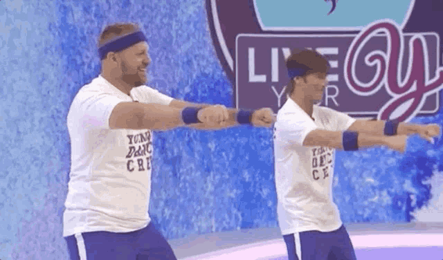 two men are doing exercises in front of a live guy sign