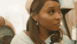 a close up of a woman wearing a headband and earrings looking to the side .