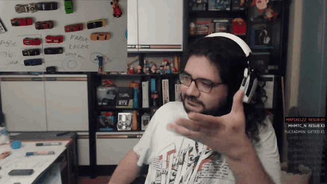 a man wearing headphones stands in front of a white board that says " agile " on it