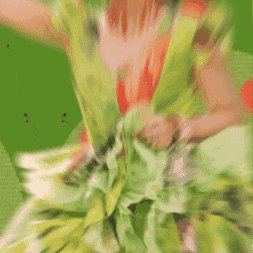a woman in a green dress with leaves on it is dancing