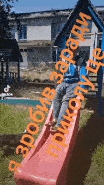 a person is sitting on a pink slide with a tiktok logo behind them