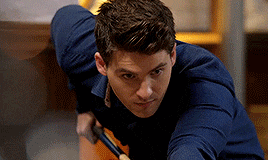 a young man in a blue shirt is holding a hammer