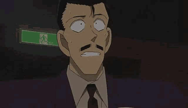 a man in a suit and tie is covering his face with his hands .