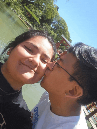 a man kisses a woman on the cheek while wearing a shirt that says o'neill on it