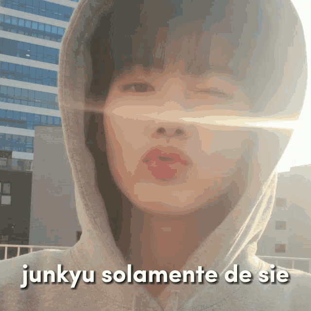 a young man wearing a hoodie with the words junkyu solamente de sie above his head