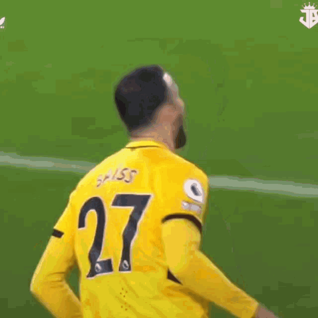 a soccer player wearing a yellow jersey with the number 27 on the back is running on the field .