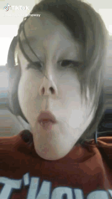 a young girl wearing a red shirt with the word duck on it makes a funny face
