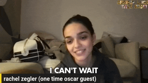 a woman is sitting on a couch and says i can 't wait rachel zegler ( one time oscar guest )