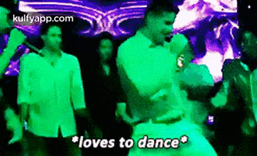 a man is dancing in a club with the words `` loves to dance '' above him .