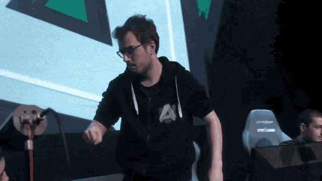 a man in a black sweatshirt with the letter a on it