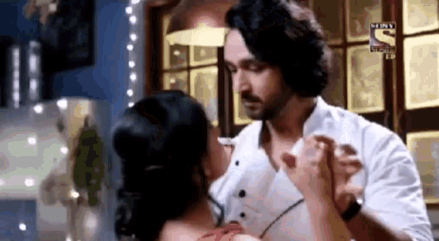 a man and a woman are dancing together in a room and holding hands .