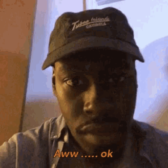 a man wearing a hat that says aww ok on it