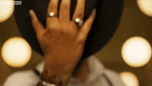 a close up of a person covering their face with their hands with the year 2005 on the bottom left