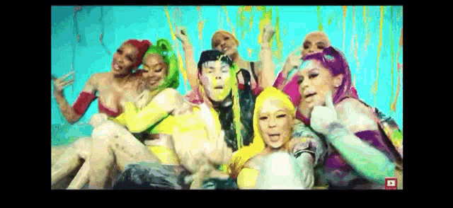 a group of people are sitting next to each other with their faces painted different colors .