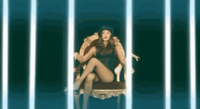 a woman is sitting in a chair with her legs crossed and a hat on .