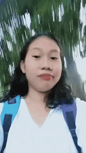 a girl wearing a white shirt and a purple backpack